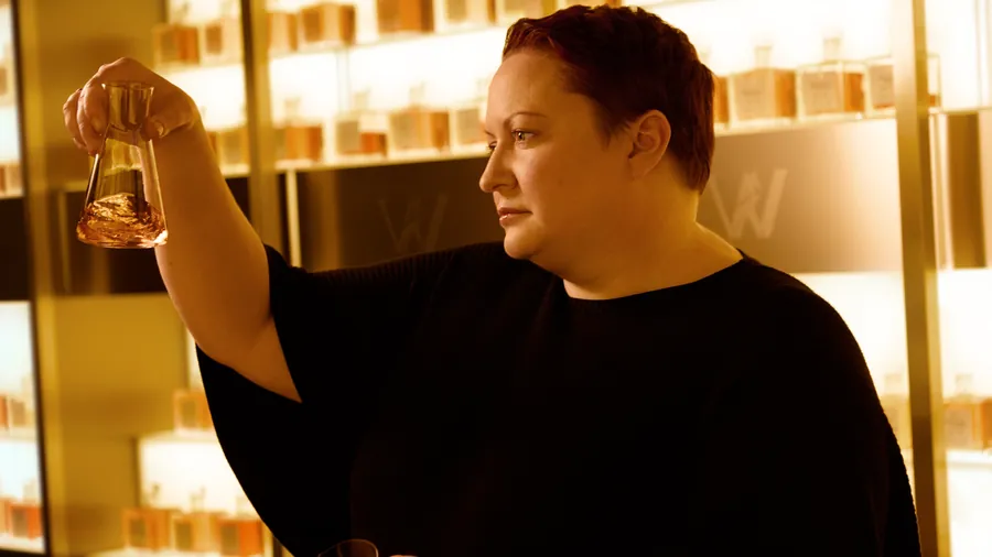 Johnnie Walker Vault: Master Blenderin Dr. Emma Walker prüft eine Whiskyprobe im Glas vor beleuchteten Regalen